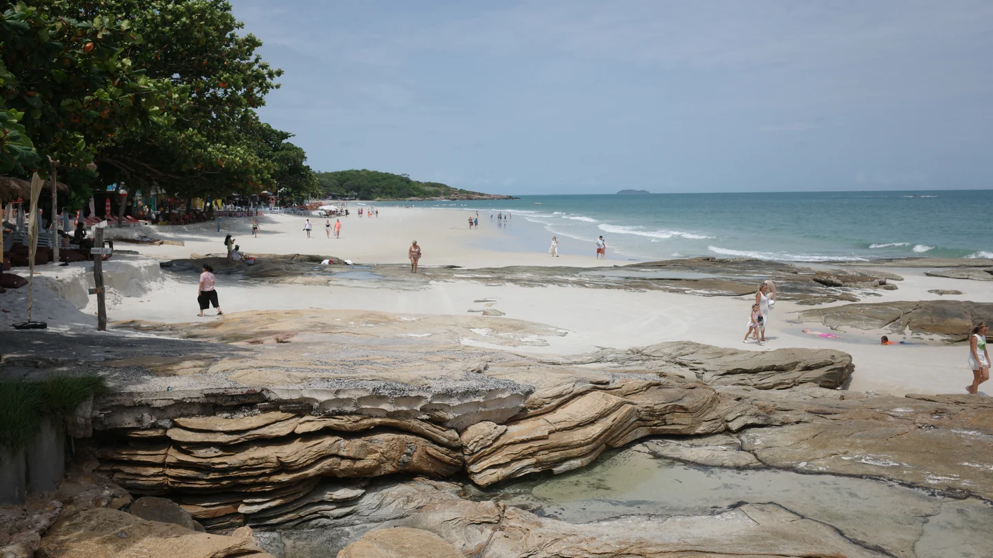White sand, coastal trees and gentle waves on a beach on Koh Samet