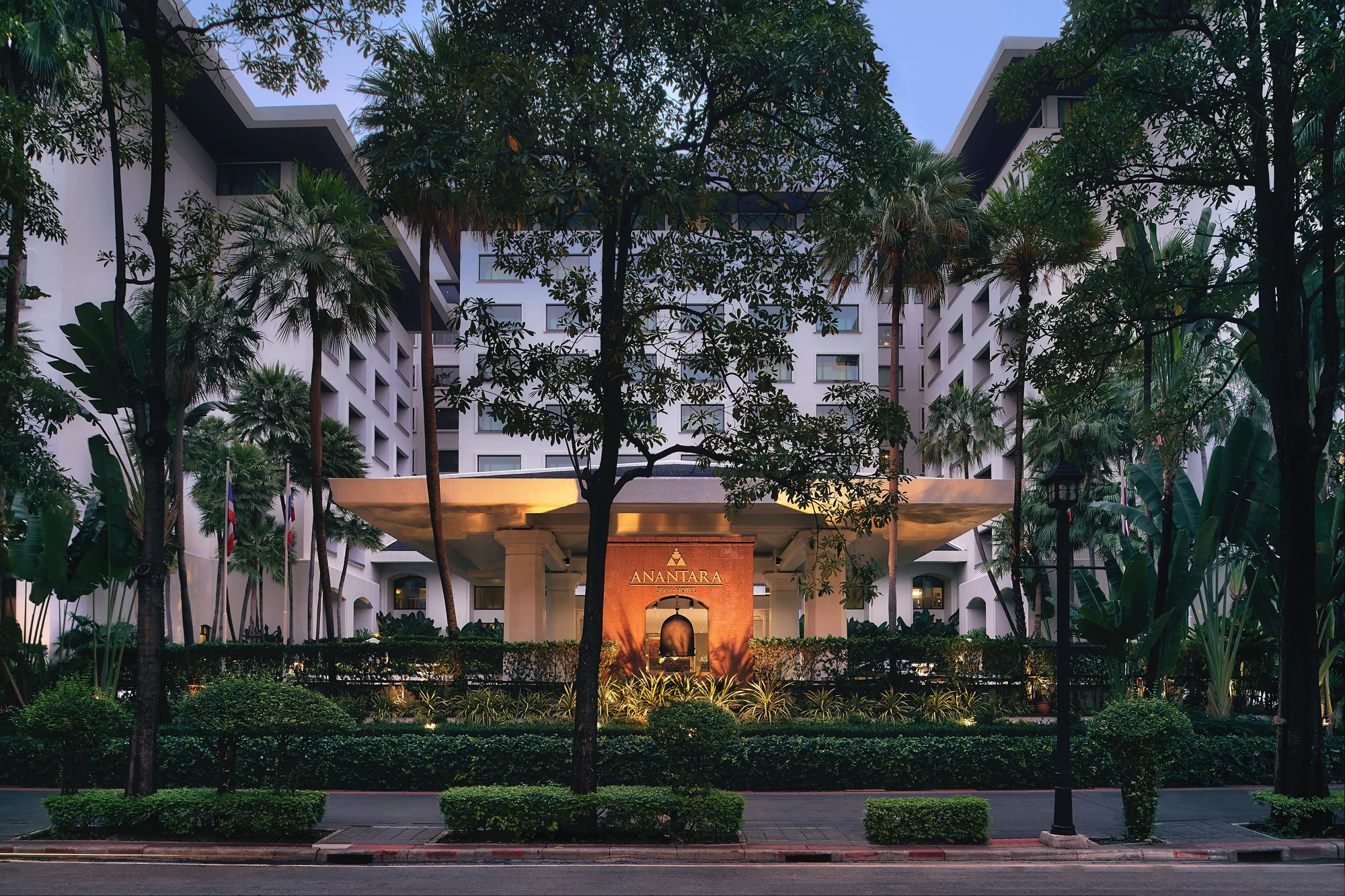 Weiße Fassade und beleuchteter Haupteingang des Anantara Siam Bangkok Hotel, fotografiert 2018