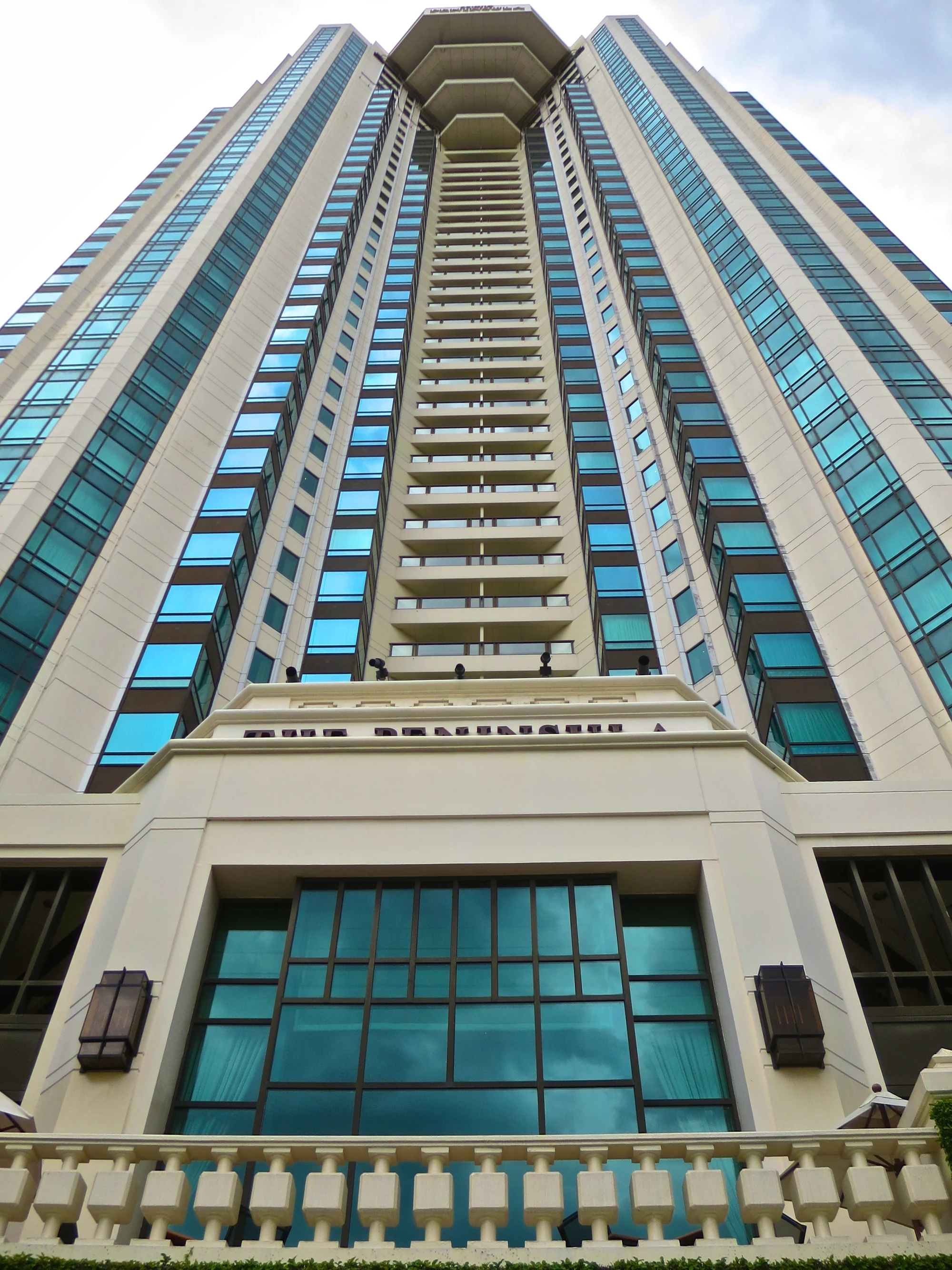 Façade de The Peninsula Bangkok photographiée en contre-plongée depuis les abords de l’hôtel