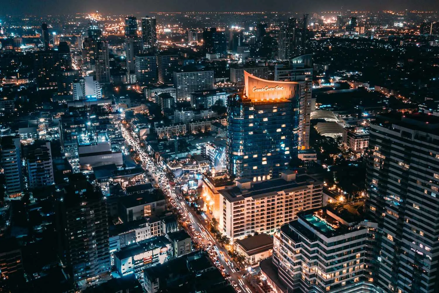夜間通羅的 Grande Centre Point Sukhumvit 55 飯店高樓,圓弧形樓頂亮起燈光