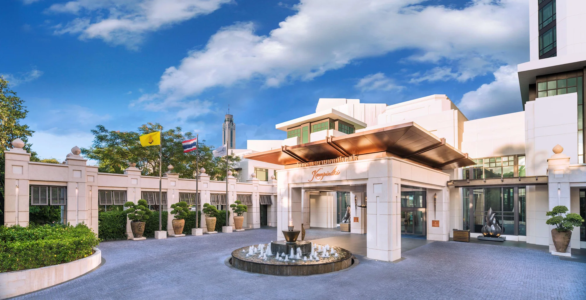 Eingang, Namensschild und Vorfahrt des Siam Kempinski Hotel Bangkok bei Tageslicht